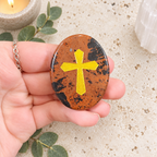 Gold Cross on Mahogany Obsidian Palm